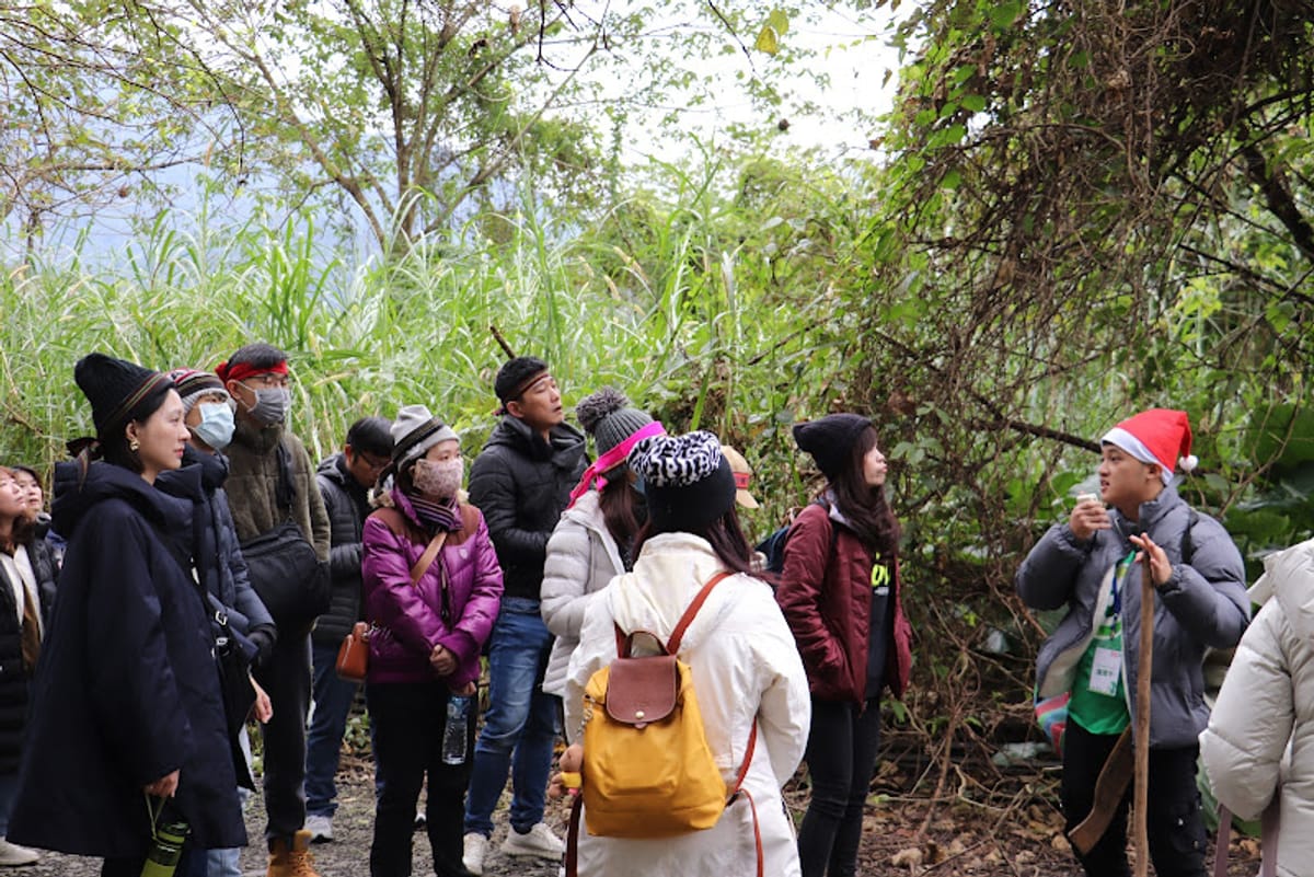 Participants gather around an eco-guide, hearing the story of the land underfoot
