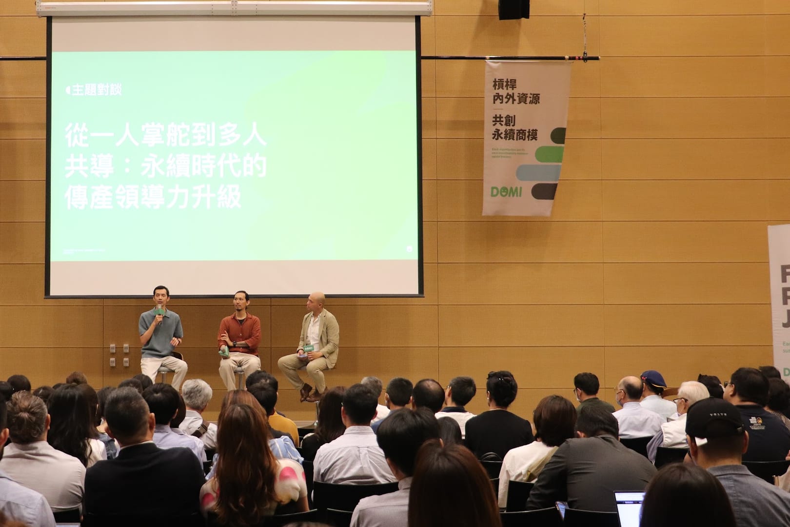 A panel discussion on stage — from one captain to shared leadership — with a full audience at a major sustainability forum